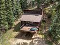 Wonderful aerial view of home featuring a deck perfect for relaxing in the woods at 28272 Shadow Mountain Dr, Conifer, CO 80433