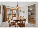Bright dining room with a wooden table and chairs, flowing to the kitchen and back deck at 1231 Missouri Ave, Longmont, CO 80501