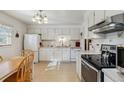 Functional kitchen with white cabinets, appliances, and a cozy breakfast nook at 1231 Missouri Ave, Longmont, CO 80501