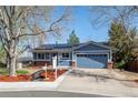 Inviting blue home featuring well-maintained landscaping, solar panels, and an attached two-car garage at 16933 E Bethany Pl, Aurora, CO 80013
