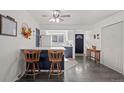 Open-concept kitchenette with breakfast bar and sleek, dark vinyl flooring at 16933 E Bethany Pl, Aurora, CO 80013