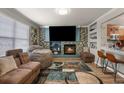 Modern living room with stone accent wall, fireplace, large TV, and unique furnishings at 4540 Crestone Peak St, Brighton, CO 80601