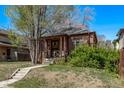 Charming brick home with a covered porch and landscaped front yard at 451 Harrison St, Denver, CO 80206