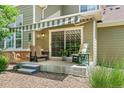 Serene back patio featuring comfortable seating, a retractable awning, and lush greenery at 1190 Telleen Ave, Erie, CO 80516