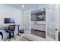 Home office with french doors, modern desk, and good natural light at 9835 Uravan St, Commerce City, CO 80022