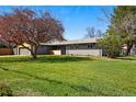 Well-maintained single story home featuring mature landscaping, an attached garage, and a green front lawn at 12345 W 32Nd Ave, Wheat Ridge, CO 80033
