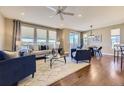 Bright living room featuring hardwood floors, large windows, and stylish furnishings at 6614 Club Villa Rd, Parker, CO 80134