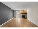 Living room with hardwood floors, stone fireplace, and sliding door access at 8555 Fairmount Dr # D204, Denver, CO 80247