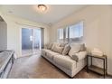 Cozy living room with a large window, sliding glass door to the outside, and a comfortable couch with neutral tones at 18270 E 51St Pl, Denver, CO 80249