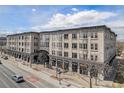 Stunning building with shops at the bottom and multiple levels of residential spaces above and beautiful blue sky background at 277 N Broadway # 202, Denver, CO 80203