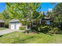 Charming two-story home featuring a well-manicured lawn, brick accents, and a two-car garage at 10247 W Roxbury Pl, Littleton, CO 80127