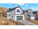 Attractive two-story home with white siding, gray garage, and a wood fence along a lightly landscaped yard at 1044 Oleander St, Castle Rock, CO 80109