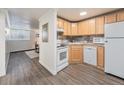 Compact kitchen featuring wood cabinets and essential appliances at 1390 N Emerson St # 105, Denver, CO 80218