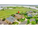 Aerial view of a home nestled near open spaces with a playground and lake views in the distance at 26631 E Arbor Dr, Aurora, CO 80016