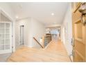 Spacious entryway with light wood floors, a staircase, and views into the living areas at 26631 E Arbor Dr, Aurora, CO 80016