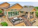 A raised deck with a fire pit, outdoor seating, and a covered area with a hot tub adds appeal at 26631 E Arbor Dr, Aurora, CO 80016