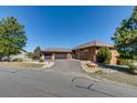 Inviting stucco house featuring an attached two-car garage and a circular driveway at 7482 Sleeping Bear Trl, Littleton, CO 80125