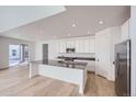 Modern kitchen with white cabinets, a large island, and stainless steel appliances at 4620 Thistle Dr, Brighton, CO 80601