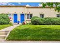 Charming home with a well-maintained lawn, blue doors and mature landscaping at 1800 Grove St, Denver, CO 80204