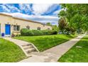 Side view of a charming home with a well-maintained lawn and mature trees at 1800 Grove St, Denver, CO 80204