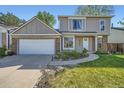 Inviting front exterior showcasing a well-maintained lawn, colorful landscaping, and a two-car garage at 10064 Owens St, Broomfield, CO 80021