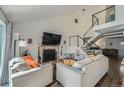 Bright living room featuring vaulted ceiling, brick fireplace and open staircase at 10064 Owens St, Broomfield, CO 80021