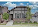 Charming home featuring stone accents, neutral colors, and a well-manicured front yard under a partly cloudy sky at 6612 N Ceylon St, Denver, CO 80249