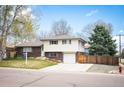 Charming home featuring a well-maintained lawn, brick accents, and a two-car garage at 1492 S Dudley St, Lakewood, CO 80232