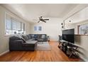Cozy living room features hardwood floors, large windows, ceiling fan, and neutral decor at 1492 S Dudley St, Lakewood, CO 80232
