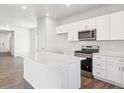 Bright kitchen with stainless steel appliances, ample cabinet space, an island and sleek countertops at 2145 Flower Blossom Ave, Brighton, CO 80601