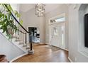 Bright foyer features hardwood floors, a staircase with black accents, and a view into a well-lit office space at 11302 E Ida Ct, Englewood, CO 80111