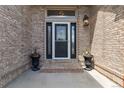 Inviting front entrance with a decorative glass door, brick accents, and charming planters creating a warm welcome at 11302 E Ida Ct, Englewood, CO 80111