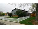 Side view of backyard featuring a wooden fence, green grass, and lilac bushes at 1528 Coronado Pkwy, Denver, CO 80229