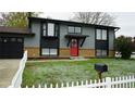 Beautiful home with a red front door, bay window, and white picket fence at 1528 Coronado Pkwy, Denver, CO 80229