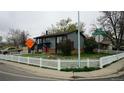 Corner lot featuring a well-maintained home with neat landscaping and a white picket fence at 1528 Coronado Pkwy, Denver, CO 80229