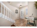 Bright entryway features tile flooring, stairs, and a glass-paneled front door at 11613 W Coal Mine Dr, Littleton, CO 80127