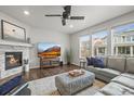 Cozy living room with a stone fireplace, a mounted TV, hardwood flooring, and neutral paint colors at 14881 Chicago St, Parker, CO 80134