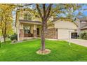 Attractive two-story home with a cozy front porch and lush green lawn at 20532 E Lake Cir, Centennial, CO 80016