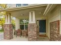 Inviting front porch with brick pillars, outdoor seating, and a welcoming front door at 20532 E Lake Cir, Centennial, CO 80016
