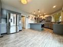Spacious kitchen with stainless steel appliances, grey cabinets, a large island, and wood-look tile flooring at 20532 E Lake Cir, Centennial, CO 80016