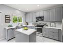 Modern kitchen featuring stainless steel appliances, an island, and sleek gray cabinetry at 5733 S Yakima Way, Aurora, CO 80015