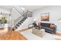 Living room with hardwood floors, stairs, contemporary furniture, and natural light at 5733 S Yakima Way, Aurora, CO 80015
