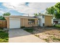 Charming brick home with an attached garage and an expansive concrete driveway at 3055 Carson St, Aurora, CO 80011
