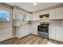Bright kitchen with white cabinets, a new stove and oven, and new laminate flooring at 3055 Carson St, Aurora, CO 80011