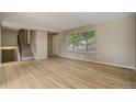 Spacious living room featuring hardwood floors, neutral paint, large window and stairs to the second level at 3055 Carson St, Aurora, CO 80011