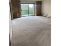 Bright living room featuring a sliding glass door to a balcony and neutral carpet, ready for personalization and offering outdoor views at 13601 E Marina Dr # 508, Aurora, CO 80014