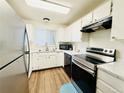 Well-lit kitchen featuring white cabinets, stainless steel appliances, and vinyl wood flooring at 8625 Clay St # 228, Westminster, CO 80031