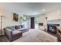 Cozy living room featuring a fireplace, plush carpet, and a sliding door to the outside at 2280 S Oswego Way # 104, Aurora, CO 80014