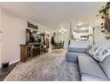Cozy living room featuring plush carpet, a fireplace, and seamless integration into the kitchen and dining area at 2280 S Oswego Way # 104, Aurora, CO 80014