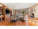 Cozy living room with built-ins, fireplace, wood trim, hardwood floors, and view to backyard at 4160 S Humboldt St, Cherry Hills Village, CO 80113